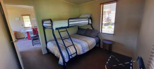 a bedroom with two bunk beds and a bed at Cedar Cottage in Takaka