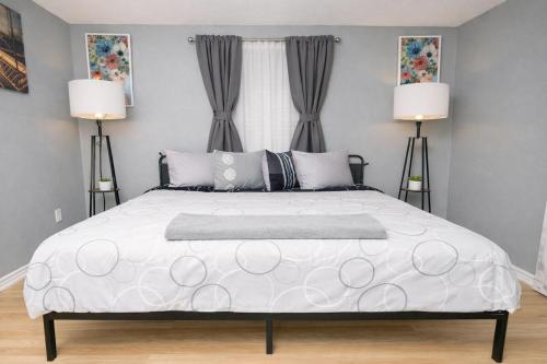 a bedroom with a large white bed with two lamps at Pool house , near downtown SA in San Antonio