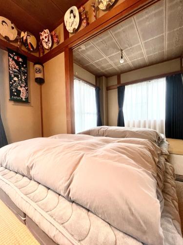 a large bed in a room with clocks on the wall at Mami and Ko house in Kawaguchi