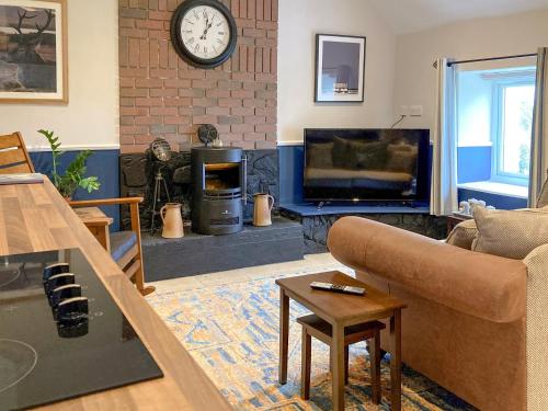 a living room with a couch and a tv at Taigh Violet Rose in Gramisdale