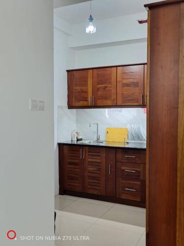 a kitchen with wooden cabinets and a sink at Urban View by CityScape in Colombo