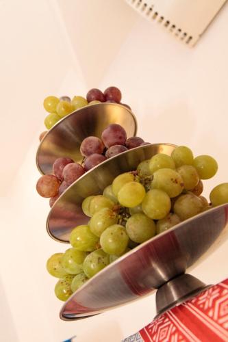a bunch of grapes in a bowl on a table at Plus Hotel in Craiova
