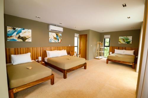 a bedroom with two beds and a tv on the wall at Cala Laiya in San Juan