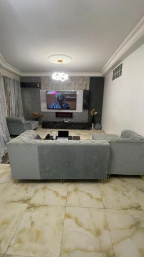 ein Wohnzimmer mit einer großen Couch und einem Flachbildfernseher in der Unterkunft Pretahouse in Dakar