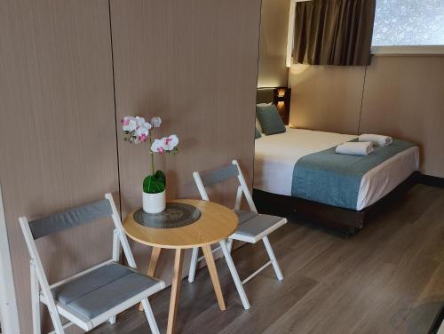 a hotel room with a table and chairs and a bed at Airway Motel in Brisbane
