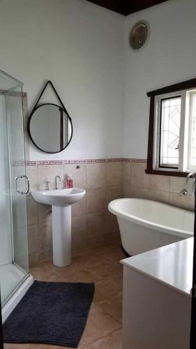 a bathroom with a tub and a sink and a bath tub at Forest Edge Cottage Dwellingup in Dwellingup