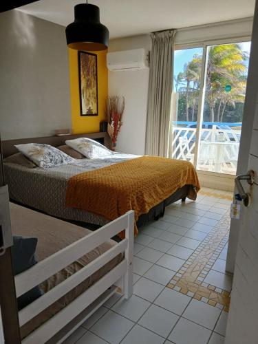 a bedroom with a bed and a large window at Ti Coco Vanni Studio Sea View in Belle-Allée