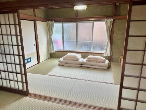 a room with a bed in front of a window at イトノ-itono- in Goto