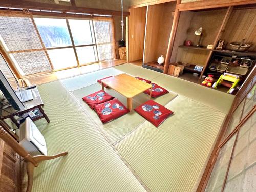 an overhead view of a living room with a table and red pillows at イトノ-itono- in Goto