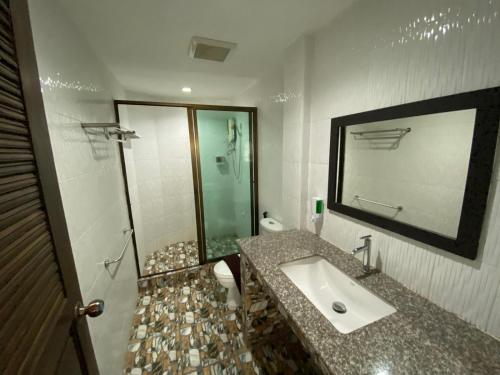a bathroom with a sink and a toilet and a mirror at La Vida Hostel Chiang Mai in Chiang Mai