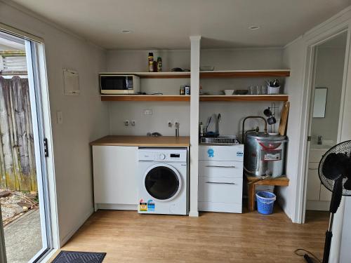 a laundry room with a washing machine and a washer at a private and sunny unit in the middle of north shore in Auckland