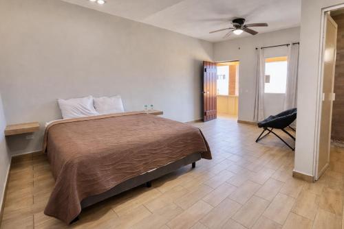 a bedroom with a bed and a chair in it at María Bonita Hotel in San José del Cabo