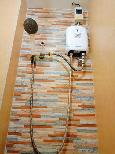 a shower with a hair dryer on the floor at Rafael Suites Inn in Mojon
