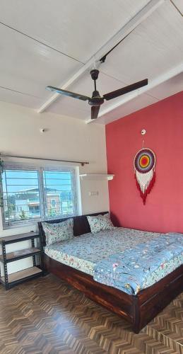 a bed in a room with a red wall at Nandi Holiday Homestay in Nandi