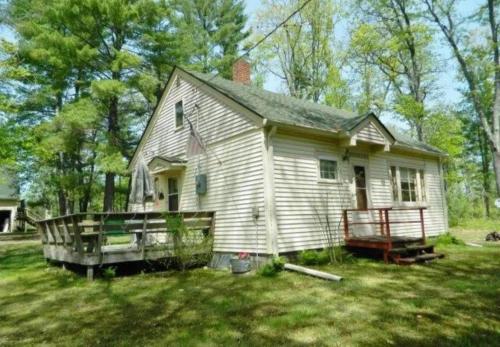 a small white house in a yard at Yellow Barn House in Danbury