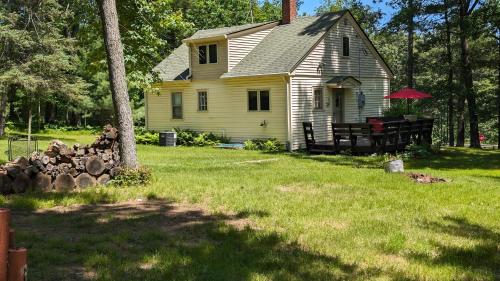a yellow house with a tree in the yard at Yellow Barn House in Danbury