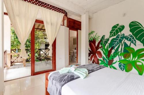 a bedroom with a bed and a large window at Hotel talú tayrona in El Zaino