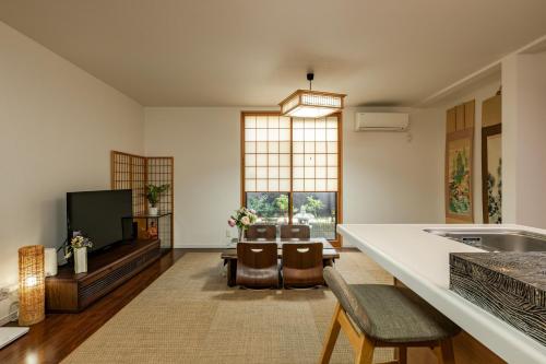 a living room with a kitchen and a tv at SummerLotus夏荷民泊 in Osaka