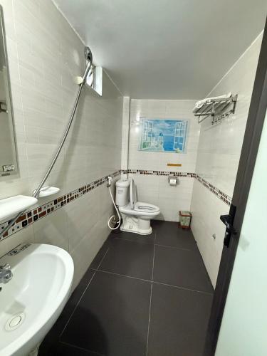 a bathroom with a white toilet and a sink at Galaxy Airport Hotel in Hanoi