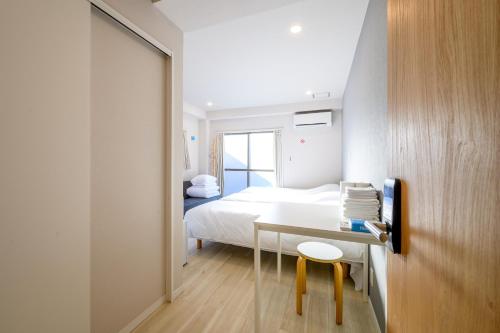 a bedroom with a bed and a desk with a chair at Kohoku Apartment in Tokyo