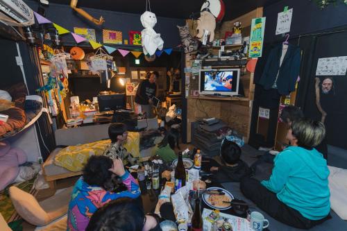 a group of people sitting in a living room watching tv at アーバンジャングル in Tokyo
