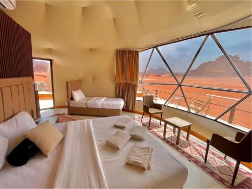 a hotel room with two beds and a large window at The bubble camp in Wadi Rum