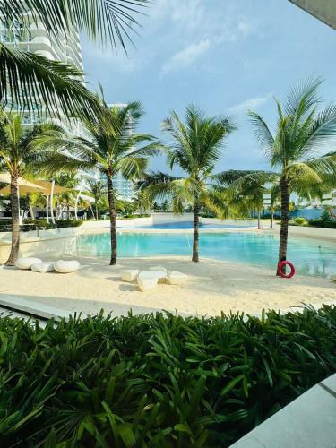 a large swimming pool with palm trees and chairs at Mekeni Azure Escape in San Fernando