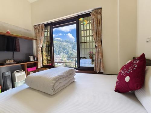 a bedroom with a large bed with a large window at 奮起湖車站 揚揚老街民宿 in Fenqihu