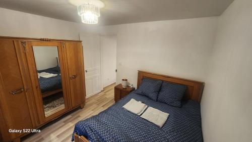 ein Schlafzimmer mit einem Bett und einem großen Spiegel in der Unterkunft GITE kass immo in Culmont