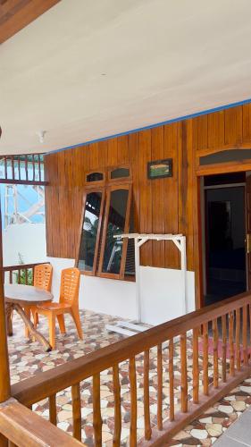a deck with a table and chairs on a house at Anugerah's House in Katiet