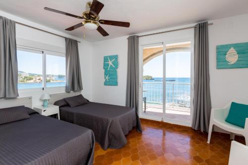 a bedroom with two beds and a view of the ocean at Zodiac Apartments in Es Cana