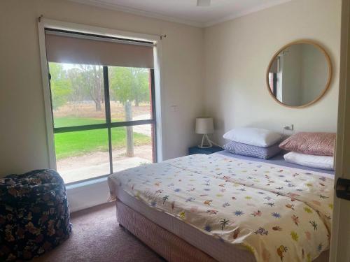 a bedroom with a bed and a large window at Wings Field - relaxing family farm stay in Tocumwal