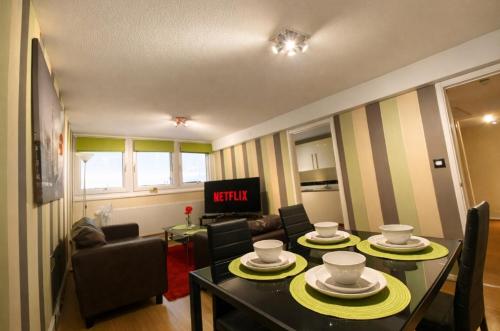 a living room with a table and chairs and a tv at Victoria Centre Apartments in the Victoria Centre Shopping Centre - Nottingham City Centre - 24 hour access - Most Central Location - Full Kitchen - Opposite Hilton - Parking for Cars or Vans from Five pounds a day - Sunday 1pm Check-out - in Nottingham