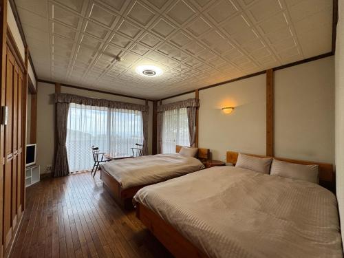 a hotel room with two beds and a table at スピークイージー in Higashiizu