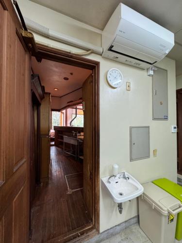a bathroom with a sink and a clock on the wall at スピークイージー in Higashiizu
