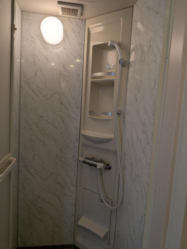 a shower in a bathroom with a refrigerator at Kagetsuen in Hakone