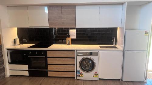a kitchen with a dishwasher and a washer at Guide Hill Station Lodge in Lake Tekapo