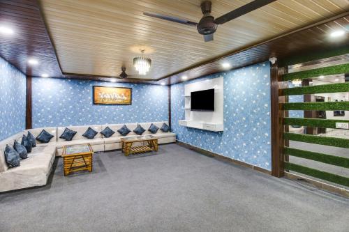a living room with a couch and a tv at Hotel O by OYO Sawariya Regency in Bhopal