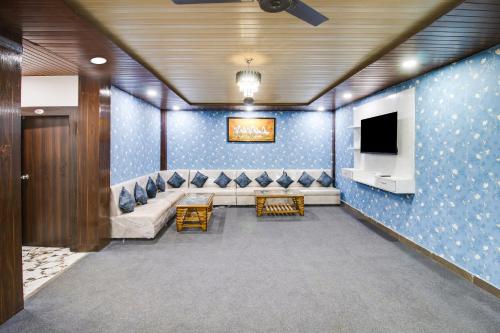 a waiting room with a couch and a tv at Hotel O by OYO Sawariya Regency in Bhopal