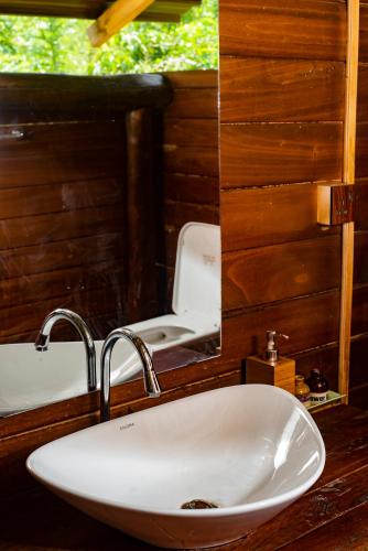 a bathroom with a sink and a toilet in a mirror at Raintree Haven in Dambulla