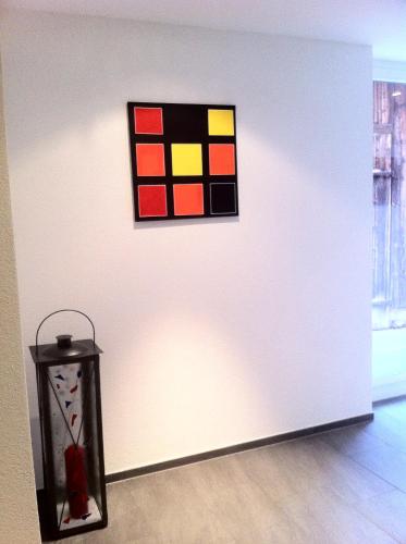 a painting on a white wall next to a table at Hotel Restaurant Jura in Kerzers