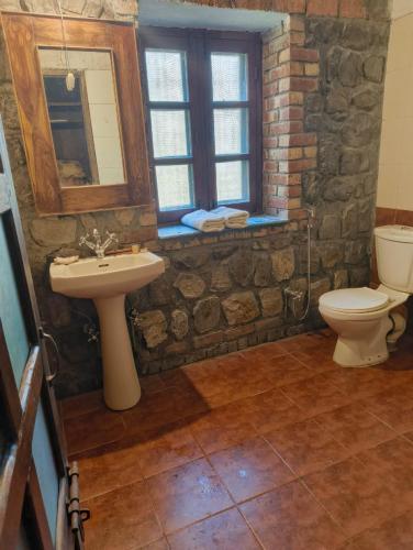 ein Steinbadezimmer mit Waschbecken und Toilette in der Unterkunft Wild Brook in Rishikesh