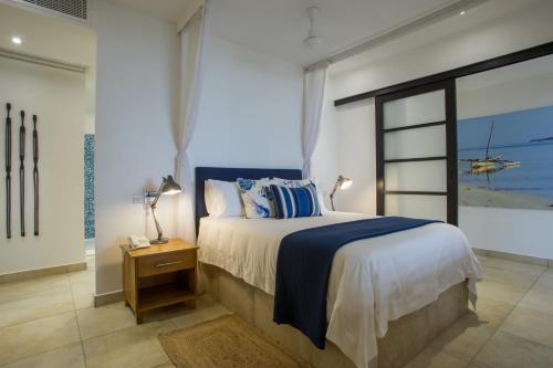 um quarto com uma cama e vista para o oceano em The Oyster Bay Hotel Suites em Dar es Salaam