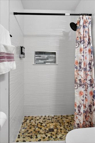 a bathroom with a shower with a shower curtain at Sleeps 17! Beach & Heated Pool, 10 minutes to all Tampa attraction! in Tampa