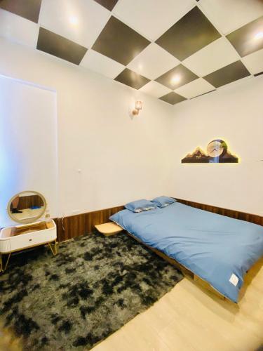 a bedroom with a bed and a checkerboard ceiling at Hoa Rừng Homestay in Xuan An