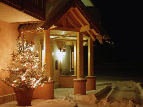 a house with a christmas tree in front of it at Residence Rio Piccolo in Molveno