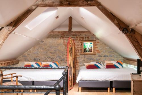 a bedroom with two beds in a attic at B&B - Hotel Le vieux marronnier in Foy-Notre-Dame