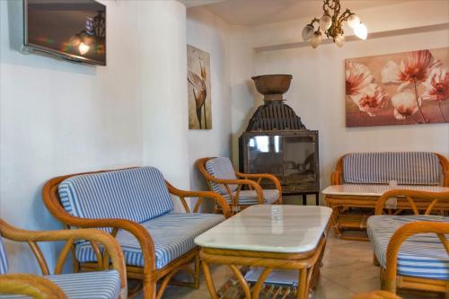Habitación con sillas, mesa y TV. en Hotel Villa Orsa, en Skiathos