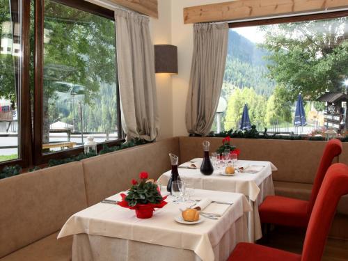 two tables in a restaurant with a view at Hotel Nigritella in Selva di Cadore