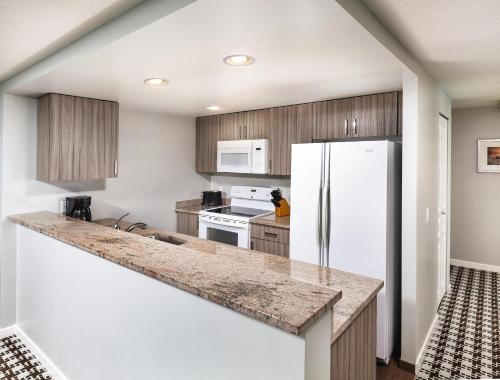 a kitchen with a white refrigerator and wooden cabinets at WorldMark Victoria in Victoria